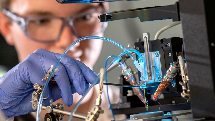Student Simon Sprengel makes some final adjustments to allow two metal solutions to flow simultaneously through the tiny printing nozzle. Photo: UOL / Daniel Schmidt.