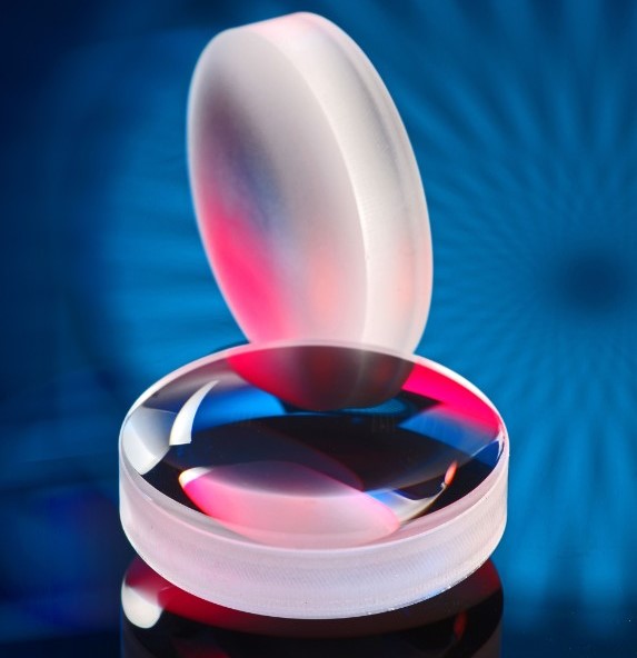 The light scatters on the surface of the polished asphere at the back. The same optics can be seen in the laser-polished state at the front. &copy; Fraunhofer ILT, Aachen, Germany.
