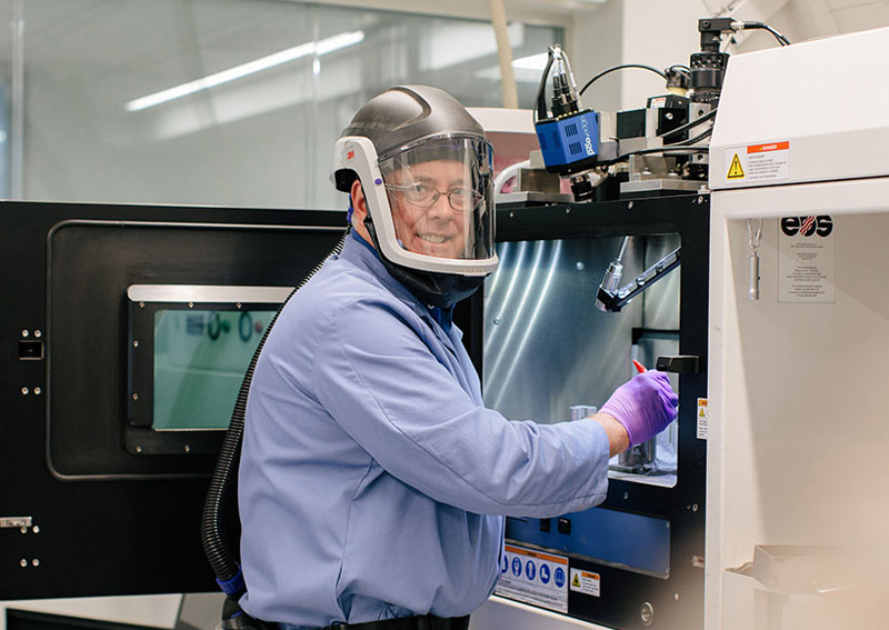 Raytheon technician operates a 3D printing machine. 