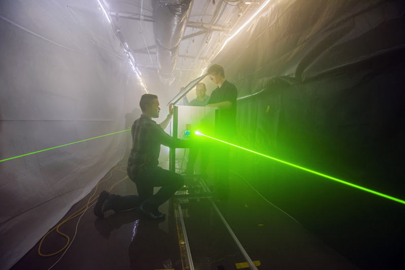 Sanchez, Wright, and Bentz prepare for an optical test in Sandia Labs’ fog facility. Sanchez, Wright, and Bentz prepare for an optical test in Sandia Labs’ fog facility.