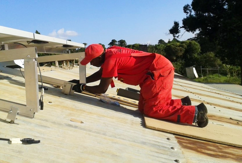 A technician preparing a solar powered refrigerator for a dispensary in Kenya. 