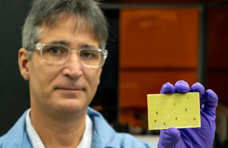 Adrian Sabau holds a primer-coated specimen, pretreated with LIS.