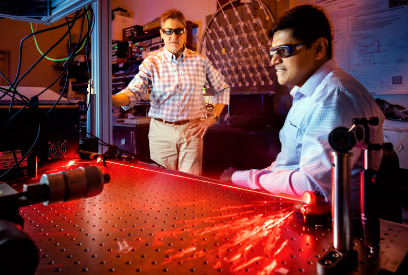 Prasad Iyer, right, and Igal Brener demonstrate optical hardware for beam steering tests. Prasad Iyer, right, and Igal Brener demonstrate optical hardware for beam steering tests.