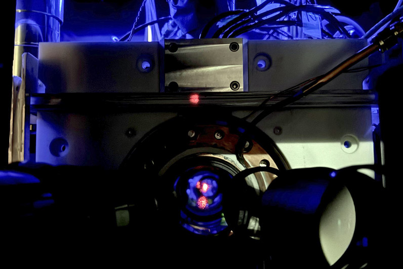 The red dot is a reflection of the laser light used to create the atom trap. The red dot is a reflection of the laser light used to create the atom trap.