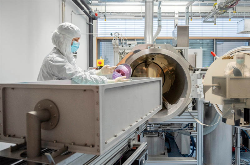 A researcher holds a highly reflective mirror for laser applications.