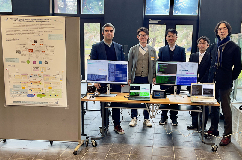 Representatives of the HHI and NICT team with their set up and paper.