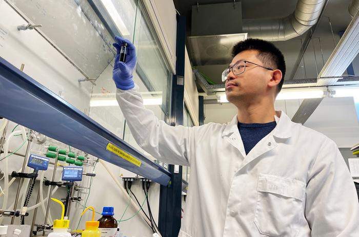 Yongjie Wang manipulating a sample of a solution of quantum dots.