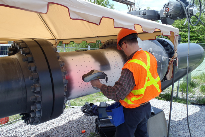 An engineer conducts 3D testing of a pipeline with a Creaform Handyscan3D scanner.