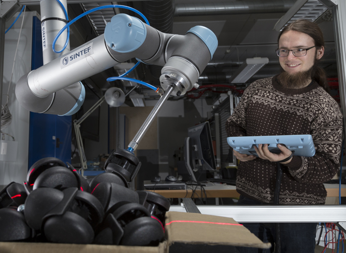 Sigurd Albrektsen calibrates the settings of two robotic arms.