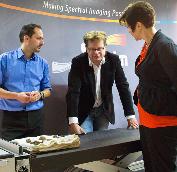 Archaeologist Jan Fast (center) studying the thousands of years-old Vantaa clay figurines.