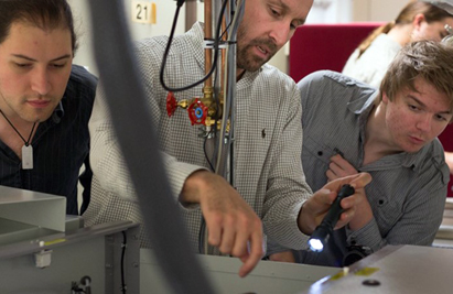 Faccio, center, working on laser system alignment and optimization with students.