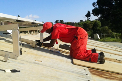 A technician preparing a solar powered refrigerator for a dispensary in Kenya. 