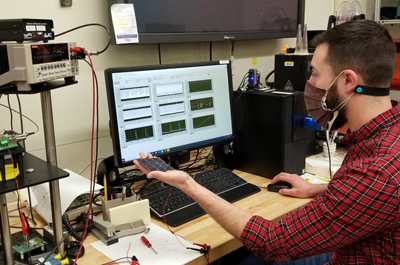 NIST researcher Andrew Shore with a miniature high efficiency solar device.