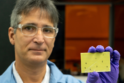 Adrian Sabau holds a primer-coated specimen, pretreated with LIS.