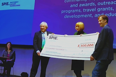 SPIE President David Andrews presents replica check to Professor Miles Padgett.