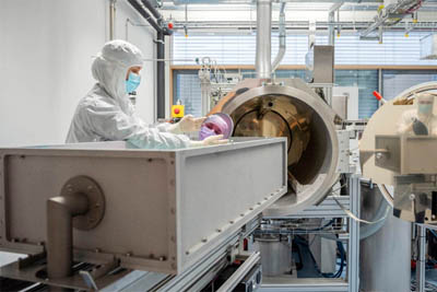 A researcher holds a highly reflective mirror for laser applications.