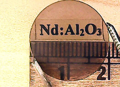 Strong and powerful: disc of neodymium-alumina laser gain material. 